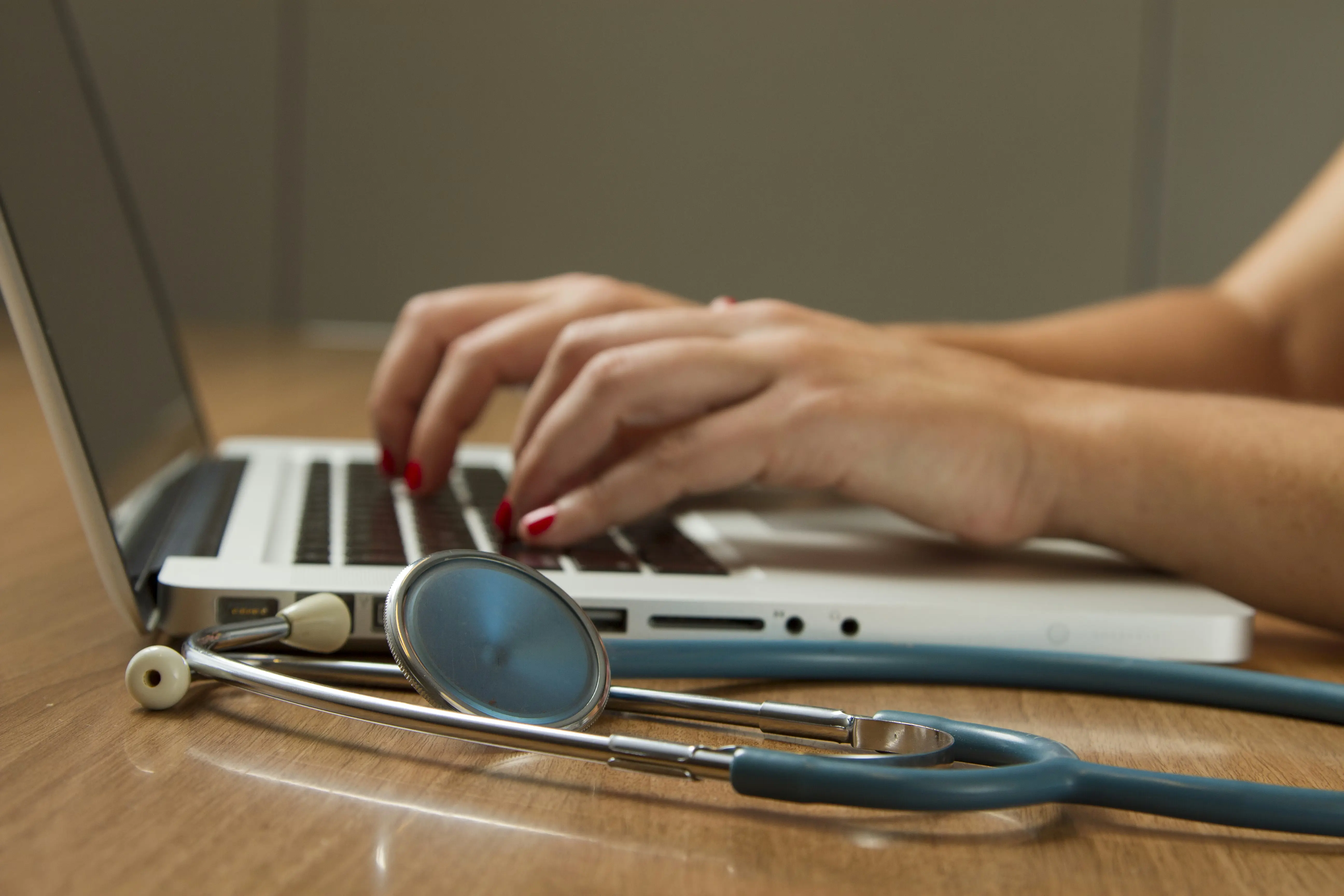 Stethoscope and clinical supplies arranged on a desk with a keyboard—medical equipment still life, no persons visible.